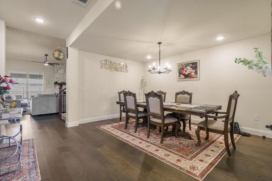 Dining room with dark wood-style flooring, a ceiling fan, and suspended lighting Dining room with dark wood-style flooring, a ceiling fan, and suspended lighting