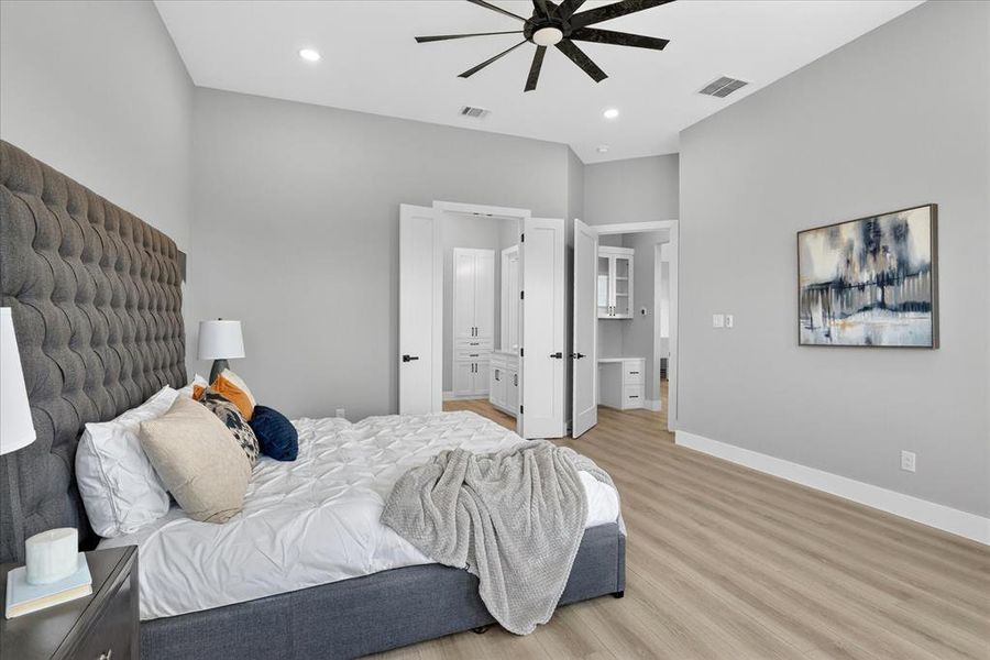Spacious room featuring vaulted ceilings, light wood-finish flooring, recessed lighting, and a contemporary ceiling fan
