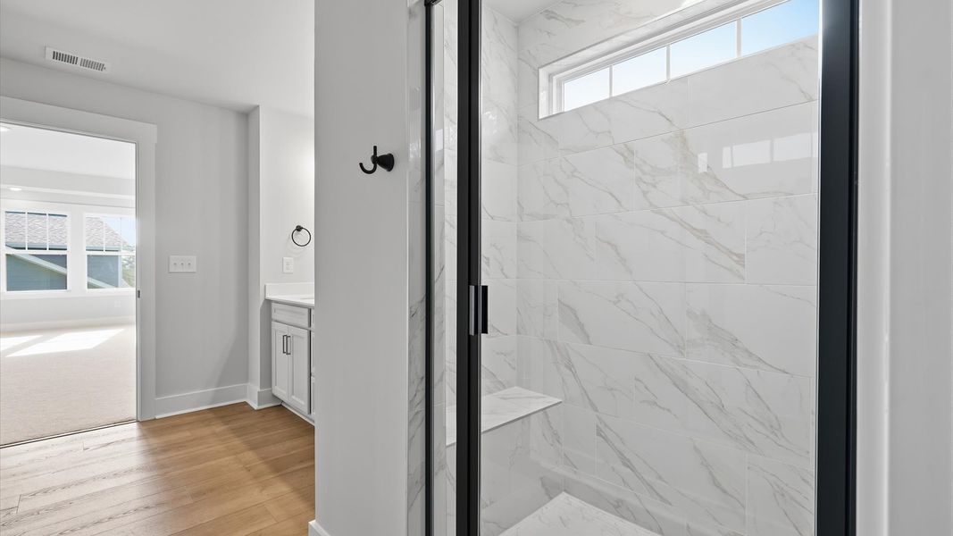 Highly functional and elegant en-suite with dual vanities, tiled walk-in shower, and refined finishes