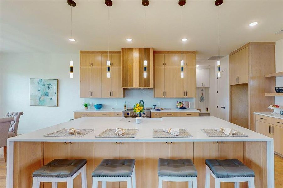 Kitchen featuring pendant lighting, light hardwood / wood-style floors, and a breakfast bar