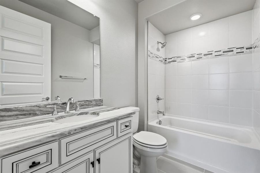 Bathroom vanity featuring a double sink with chrome fixtures and a stone-finish countertop