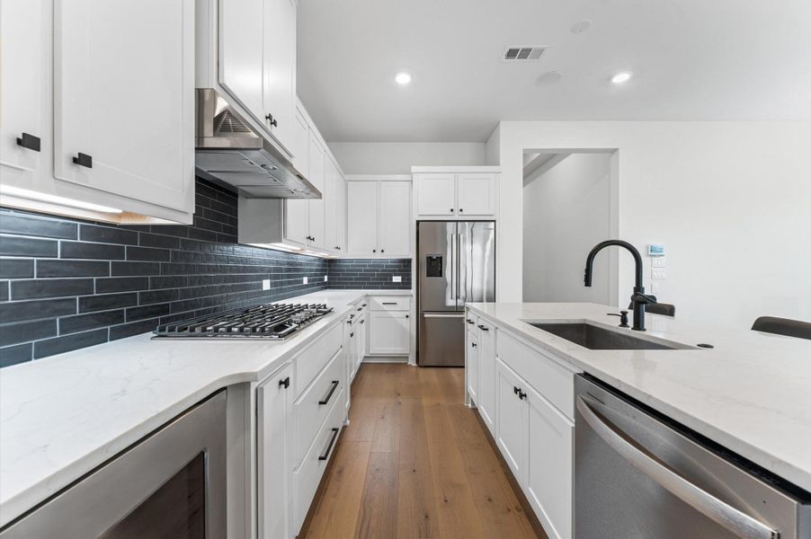 Sleek subway tile backsplash, deep farmhouse sink, and crisp white cabinetry — clean, classic, and easy to love every single day.