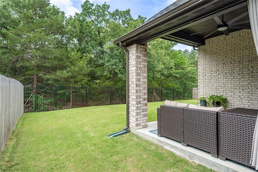 Patio and back yard view of woods behind the home.