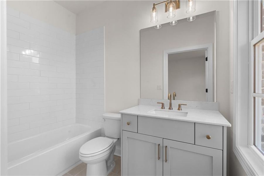Bathroom featuring tub / shower combination, vanity, and light tile patterned floors