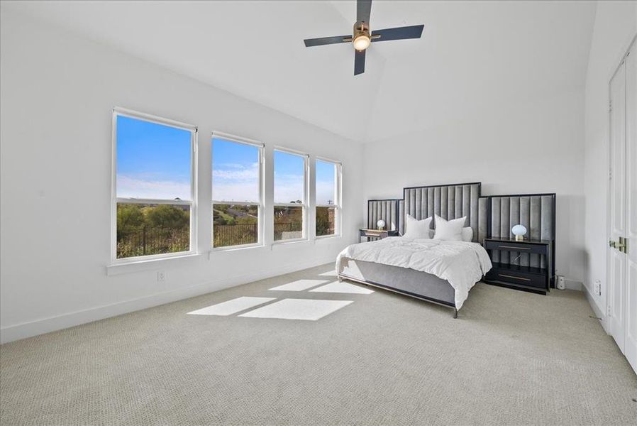 Bedroom with high vaulted ceiling, carpet, ceiling fan, and baseboards