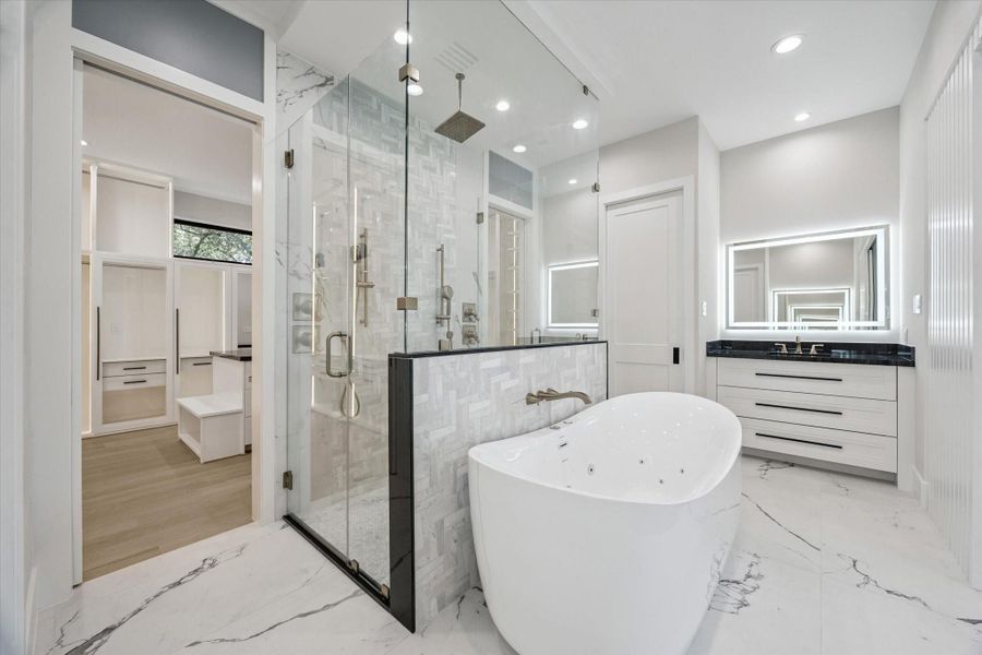 Flanking the space are dual vanities and private water closets for added convenience and privacy.