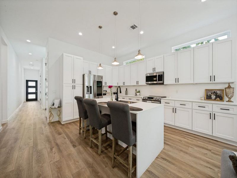 A chef's kitchen features stainless steel appliances, abundant cabinetry, and a substantial island for casual dining. A chef's kitchen features stainless steel appliances, abundant cabinetry, and a substantial island for casual dining.