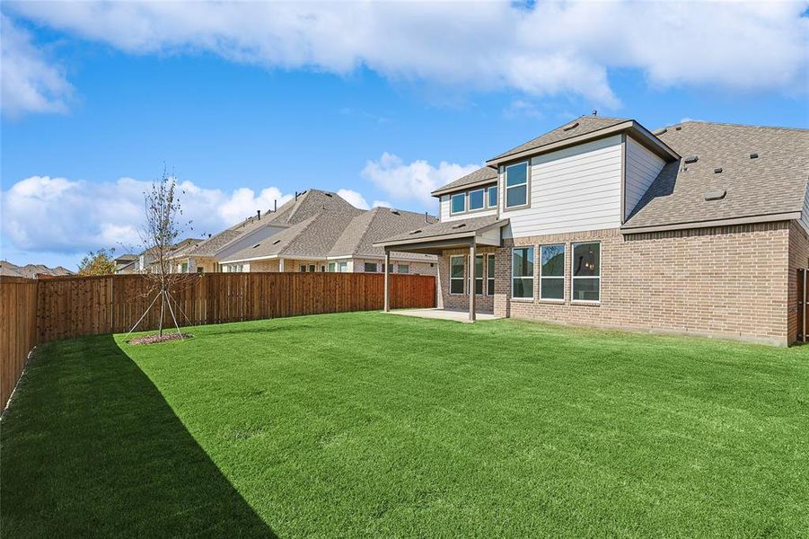 Rear view of house with a patio area and a lawn