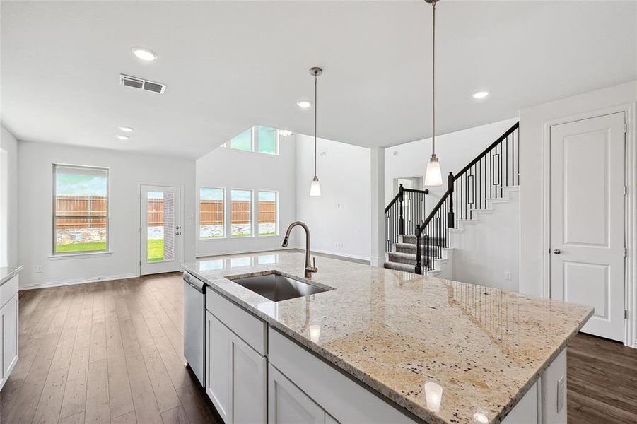 Kitchen with a center island with sink, dark wood-type flooring, white cabinetry, and sink