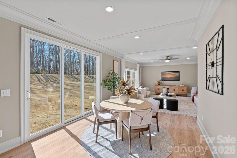 Seamless indoor-outdoor living with a collapsible 9’ stacking patio door opening to the landscaped backyard - framed by mature oak and pine trees.