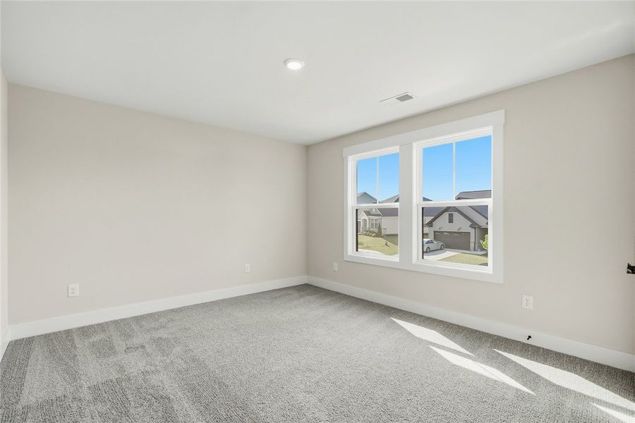 Plush carpeting and large double windows create a