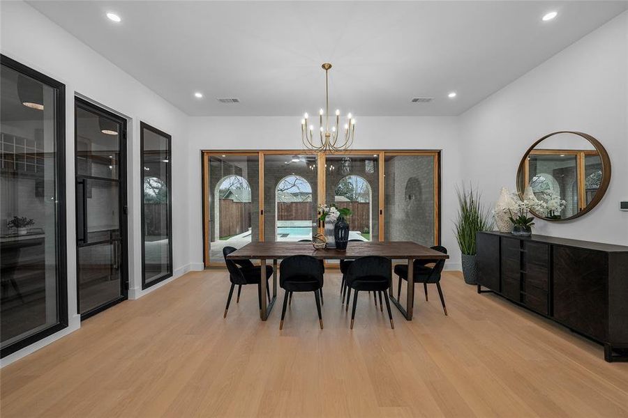 Dining space featuring hanging lights and light wood-style floors Dining space featuring hanging lights and light wood-style floors