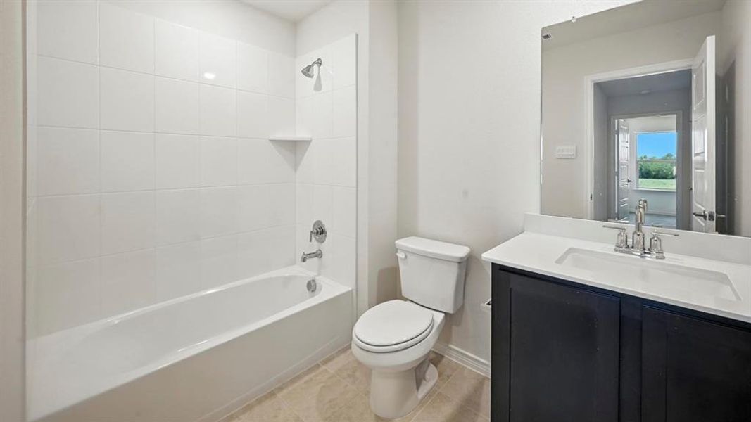 Bathroom with bathing tub / shower combination, vanity, and light tile patterned floors