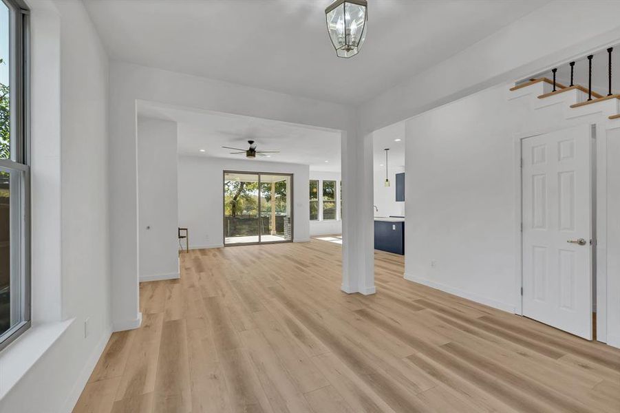 Unfurnished living room with light wood-type flooring, recessed lighting, and stairway