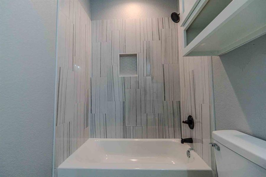 Full bath with a textured wall and washtub / shower combination Full bath with a textured wall and washtub / shower combination
