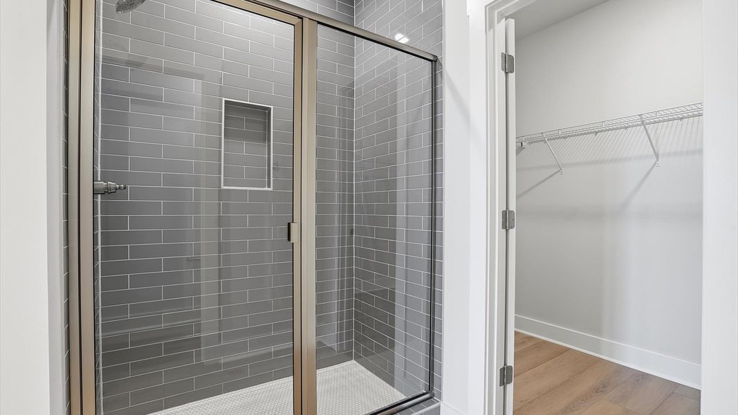 Memorable mornings begin in this elegant primary bathroom with an elegant walk-in shower located at Village at Midway