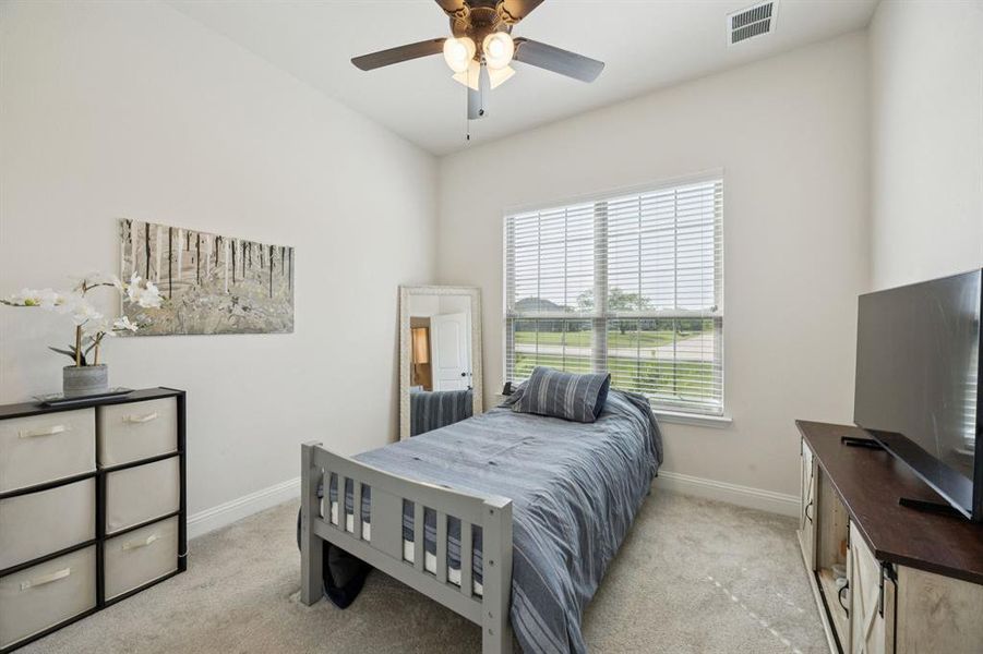 Bedroom with light carpet and a ceiling fan