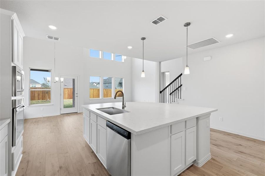 Kitchen featuring white cabinets, pendant lighting, light wood-type flooring, appliances with stainless steel finishes, and recessed lighting Kitchen featuring white cabinets, pendant lighting, light wood-type flooring, appliances with stainless steel finishes, and recessed lighting
