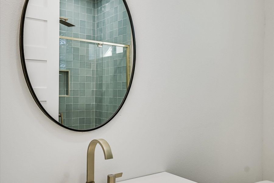 Reflecting modern elegance, a vanity with a sleek gold faucet sets a luxurious tone.