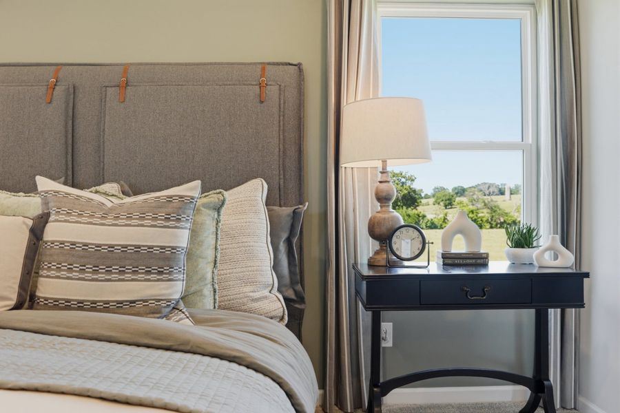 A bed with a lamp and a table with a clock on it. A bed with a lamp and a table with a clock on it.