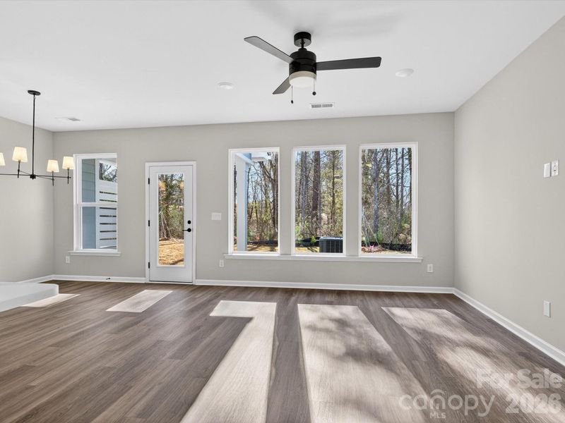 Living room area features 3 large picture windows that bathe the room in natural light & have views of the wooded backyard.