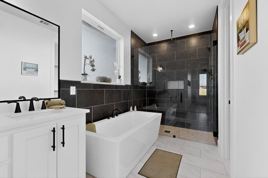 Bathroom with vanity, a freestanding bath, a stall shower, tile walls, and recessed lighting Bathroom with vanity, a freestanding bath, a stall shower, tile walls, and recessed lighting