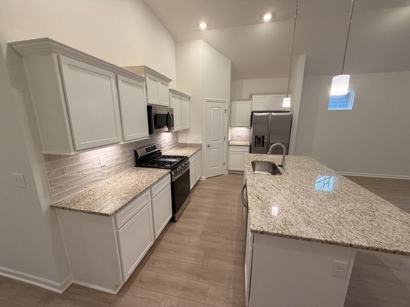 Stock Photo: Kitchen features a Large Island topped with Granite, Gas Range and Corner Pantry!