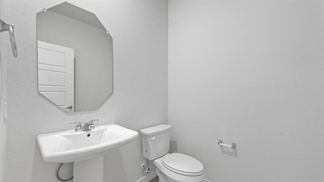 Half bathroom featuring a textured wall Half bathroom featuring a textured wall