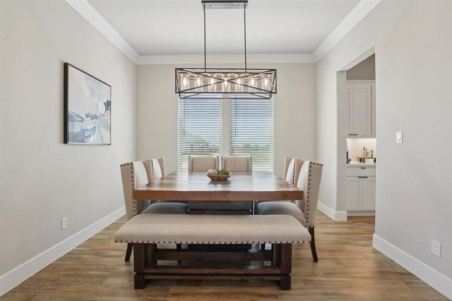 Dining room featuring light wood finished floors and ornamental molding