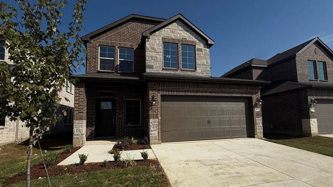View of front facade with brick siding, concrete driveway, stone siding, and a porch View of front facade with brick siding, concrete driveway, stone siding, and a porch