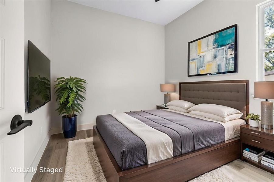 Bedroom with wood finished floors and baseboards