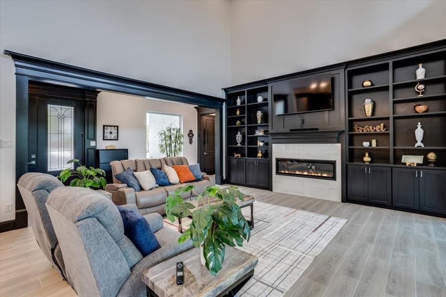 Living area featuring tiled floors, a tiled fireplace, and a high ceiling