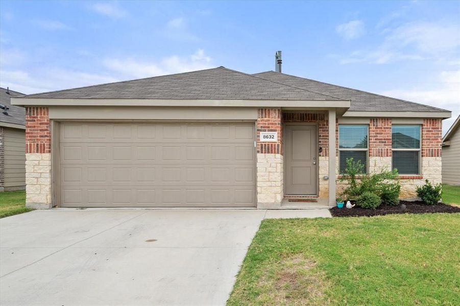 Single story home with brick siding, roof with shingles, a garage, driveway, and a front lawn