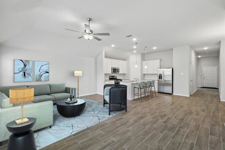 Living area featuring light wood-style floors, ceiling fan, vaulted ceiling, and recessed lighting Living area featuring light wood-style floors, ceiling fan, vaulted ceiling, and recessed lighting