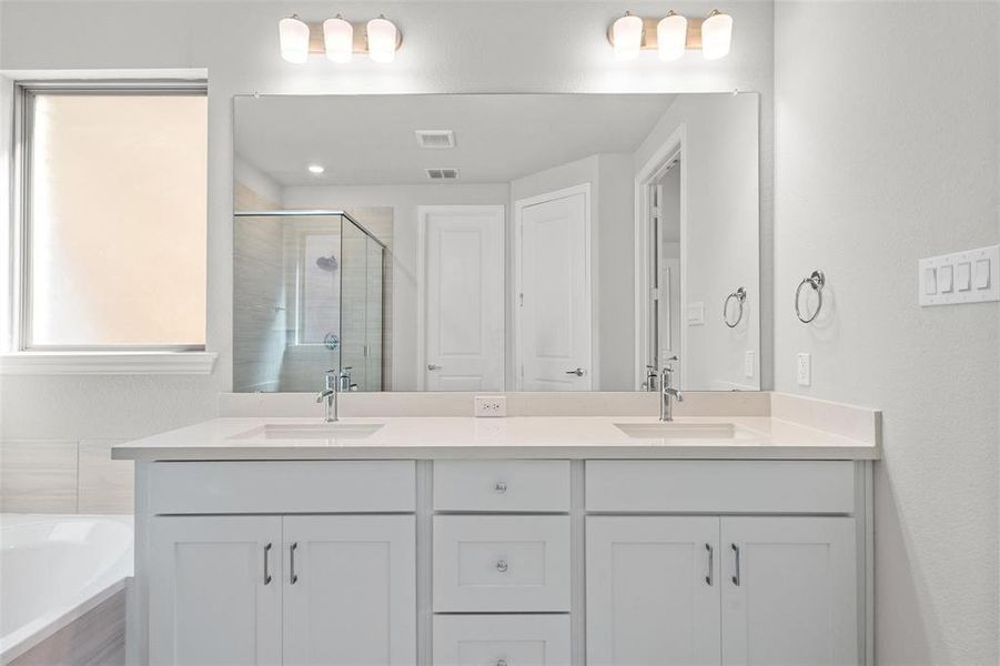 Bathroom featuring separate shower and tub and vanity