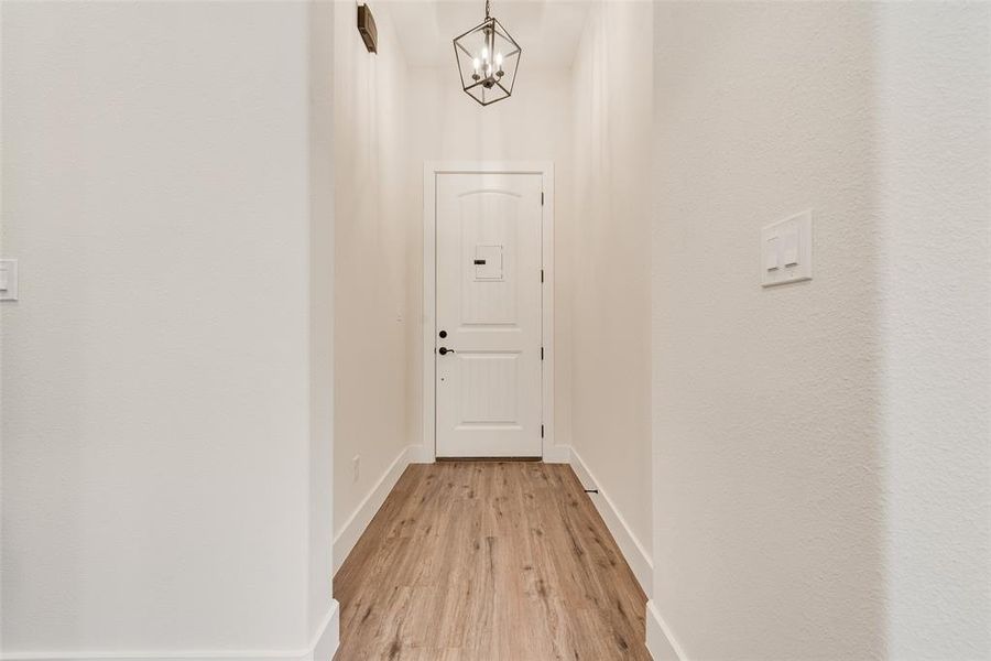 Doorway featuring wood finished floors and a chandelier