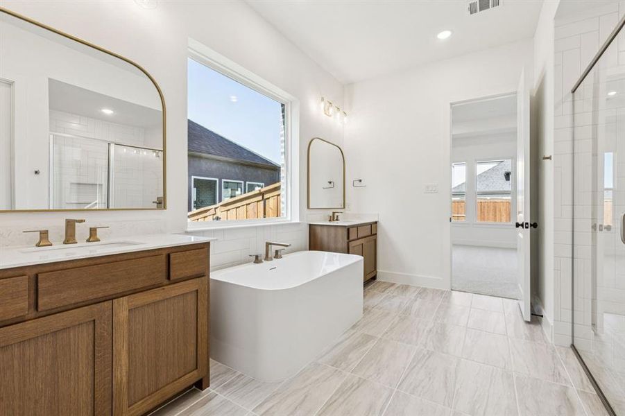 With his & her vanities, a wonderful soaking tub and spacious walk in shower, you will love everything this over the top owner's bath has to offer!