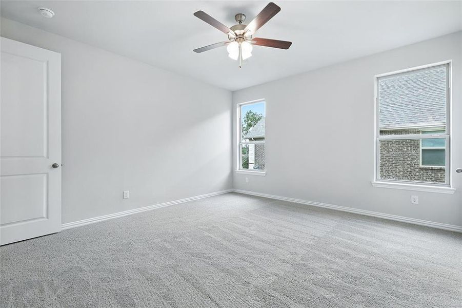 Carpeted empty room featuring a smoke detector and a ceiling fan Carpeted empty room featuring a smoke detector and a ceiling fan