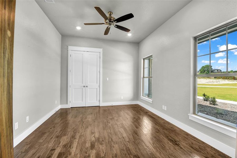 Kitchen with tasteful backsplash, stainless steel appliances, decorative light fixtures, dark wood-type flooring, and a kitchen island with sink