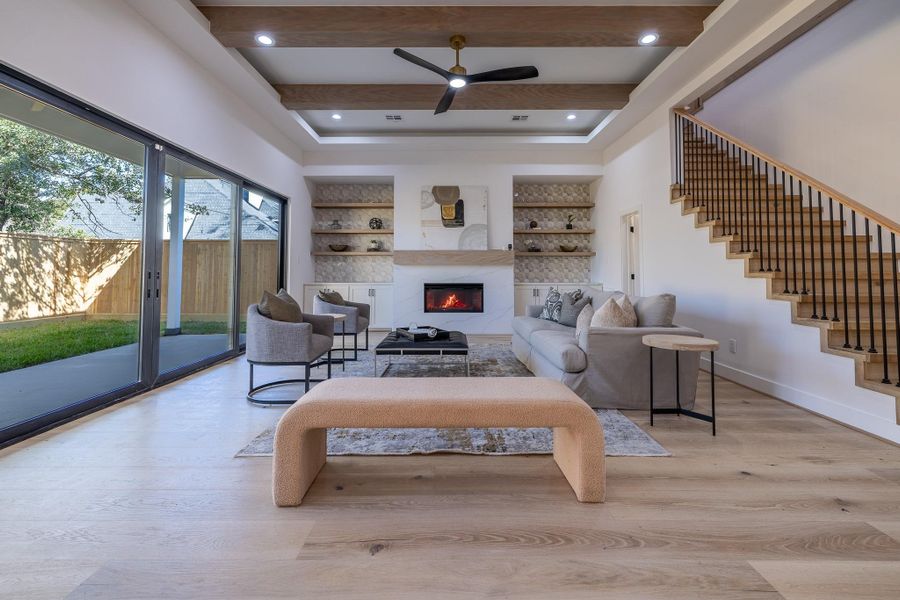 Light-filled family room featuring soaring ceilings, exposed beam detail, and expansive sliding doors creating seamless indoor-outdoor flow.