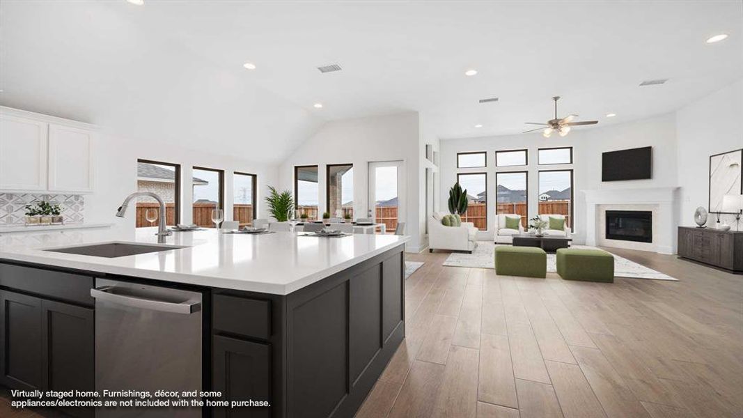 Kitchen featuring plenty of natural light, a glass covered fireplace, open floor plan, and a sink