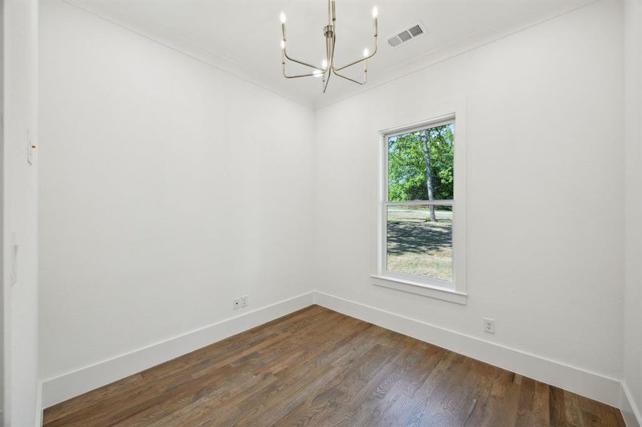 Office with a chandelier, crown molding, a healthy amount of sunlight, and dark wood-style floors Office with a chandelier, crown molding, a healthy amount of sunlight, and dark wood-style floors