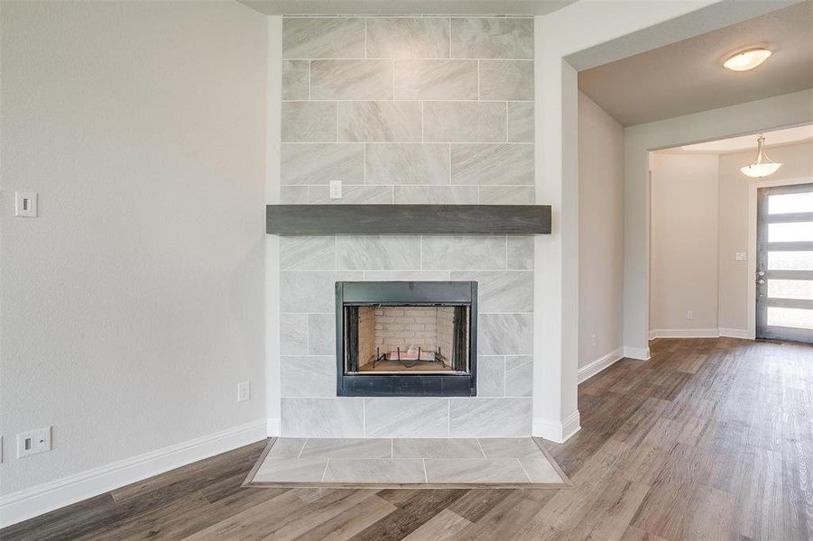 Room details featuring hardwood / wood-style flooring and a tile fireplace