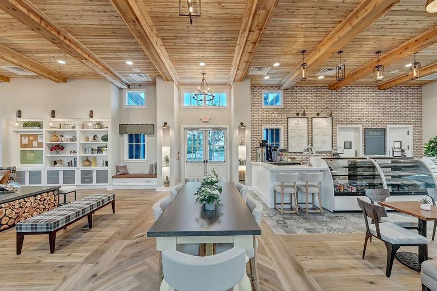 Living room with brick wall, a wooden ceiling with exposed beams, a towering ceiling, and light wood-style floors Living room with brick wall, a wooden ceiling with exposed beams, a towering ceiling, and light wood-style floors