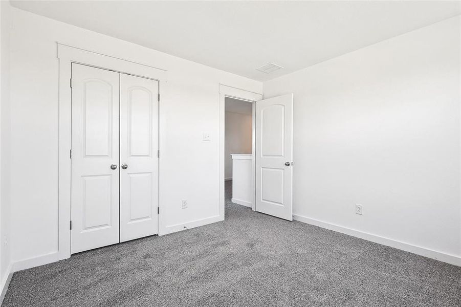 Unfurnished bedroom featuring carpet and a closet