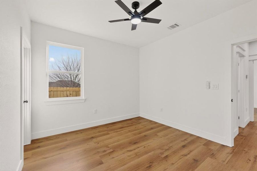 Unfurnished room featuring light wood finished floors and a ceiling fan Unfurnished room featuring light wood finished floors and a ceiling fan