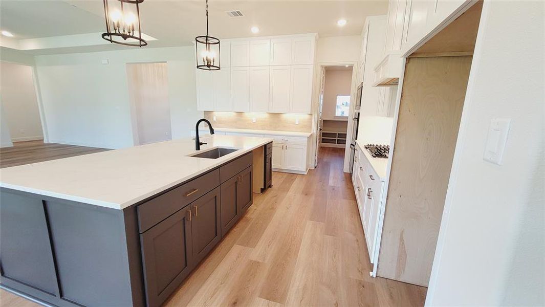 Expansive kitchen island featuring a light-toned countertop and matte gray cabinetry
