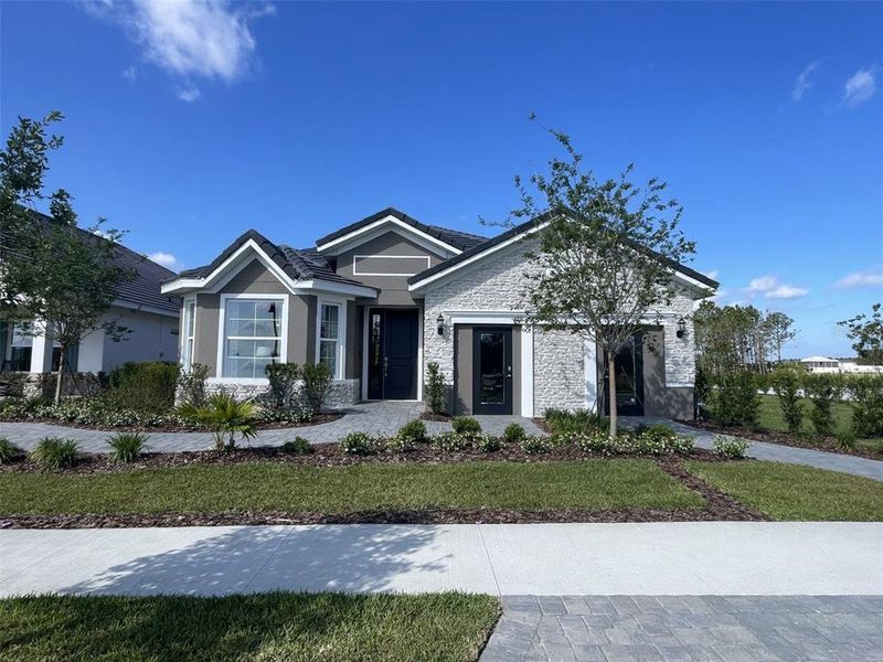 Front exterior of a new home in Tamarack at Two Rivers, Zephyrhills, FL, highlighting curb appeal (Image 2). Front exterior of a new home in Tamarack at Two Rivers, Zephyrhills, FL, highlighting curb appeal (Image 2).