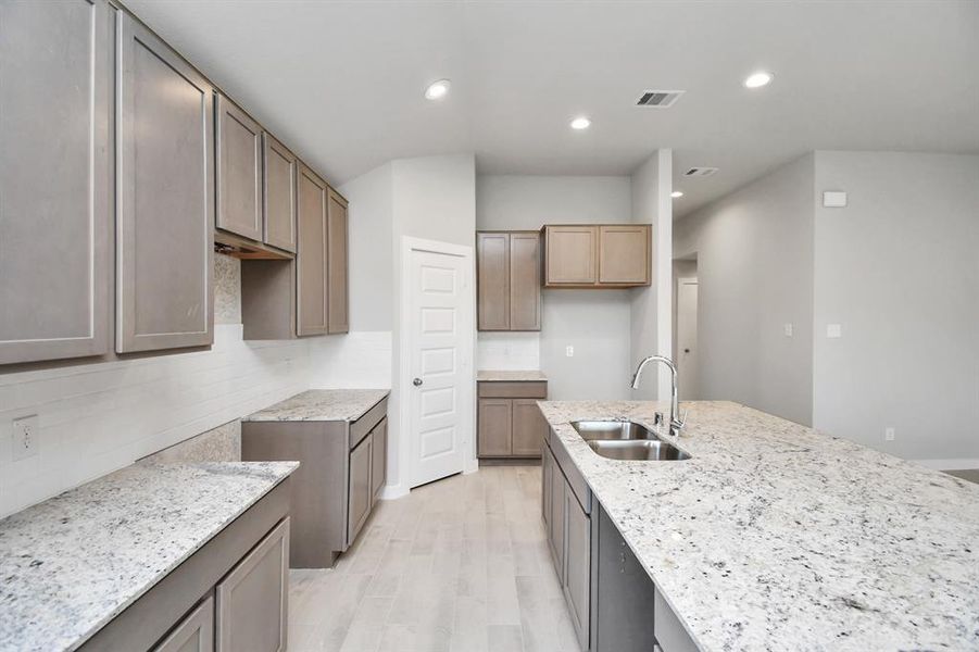 Discover another perspective of this stunning kitchen, generously appointed with an abundance of counter space.  Sample photo of completed home with similar floor plan. Actual colors and selections may vary.