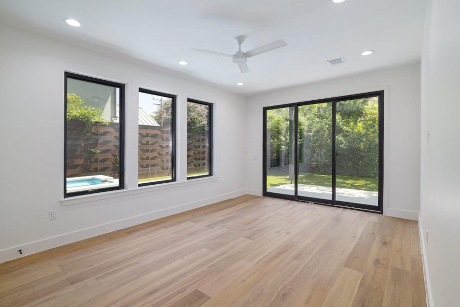 Spacious interior with wide plank wood-finish flooring, recessed lighting, and a modern ceiling fan